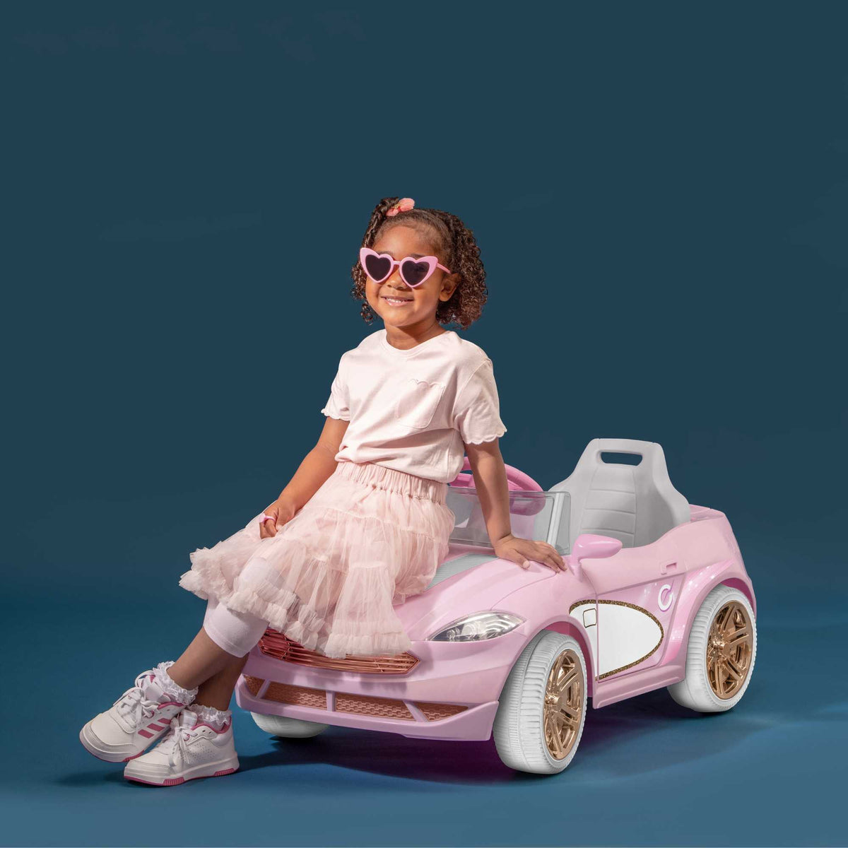 Pink EVO Dream Coupe Car Ride-On Toy for children aged 3+, featuring pedal-driven forward and reverse motion, working headlights, and authentic engine and horn sounds