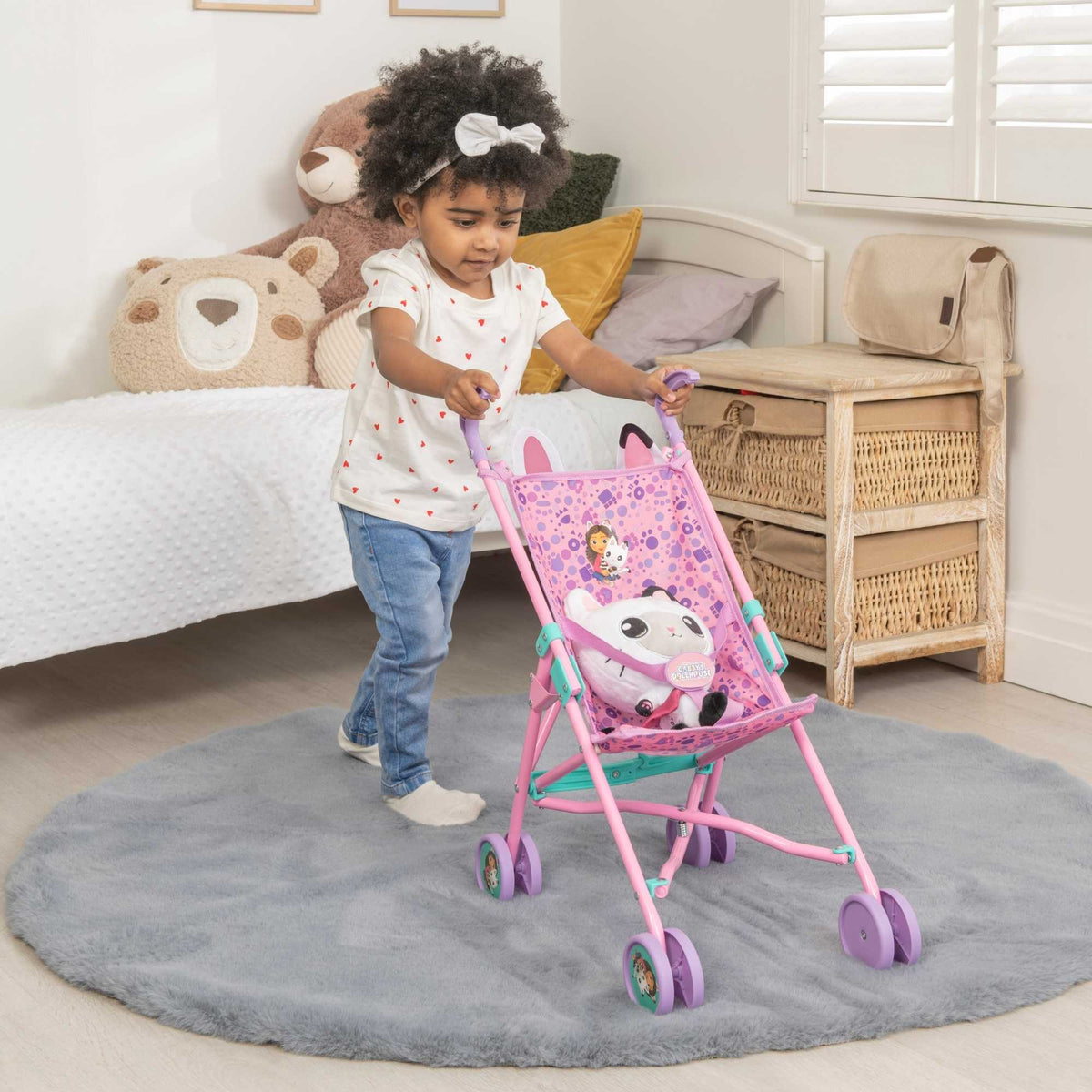 Colourful toy stroller featuring popular characters from Gabby&#39;s Dollhouse, designed for children to enjoy pretend play. Ideal for carrying dolls and other small toys, with vibrant designs and sturdy wheels for easy manoeuvrability.