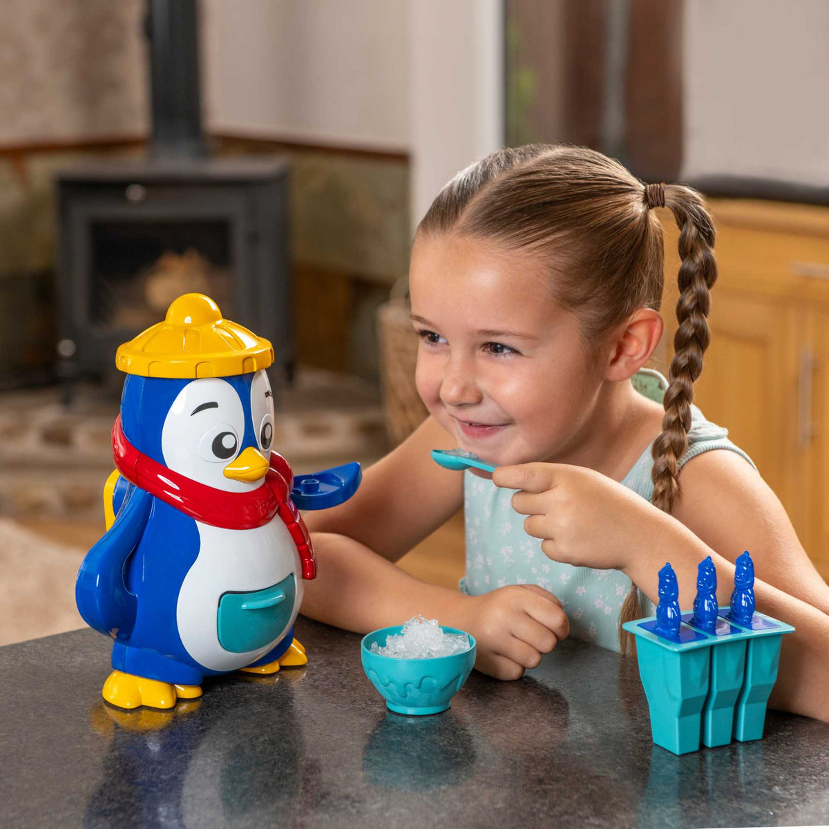 Polar Penguin Ice Maker Toy Set featuring a penguin-shaped ice crusher, ice lolly moulds, ice cube tray, and a bottle for syrups. Perfect for kids, this fun and educational set allows them to create delicious frozen treats, promoting creativity and learning about the science of freezing. 