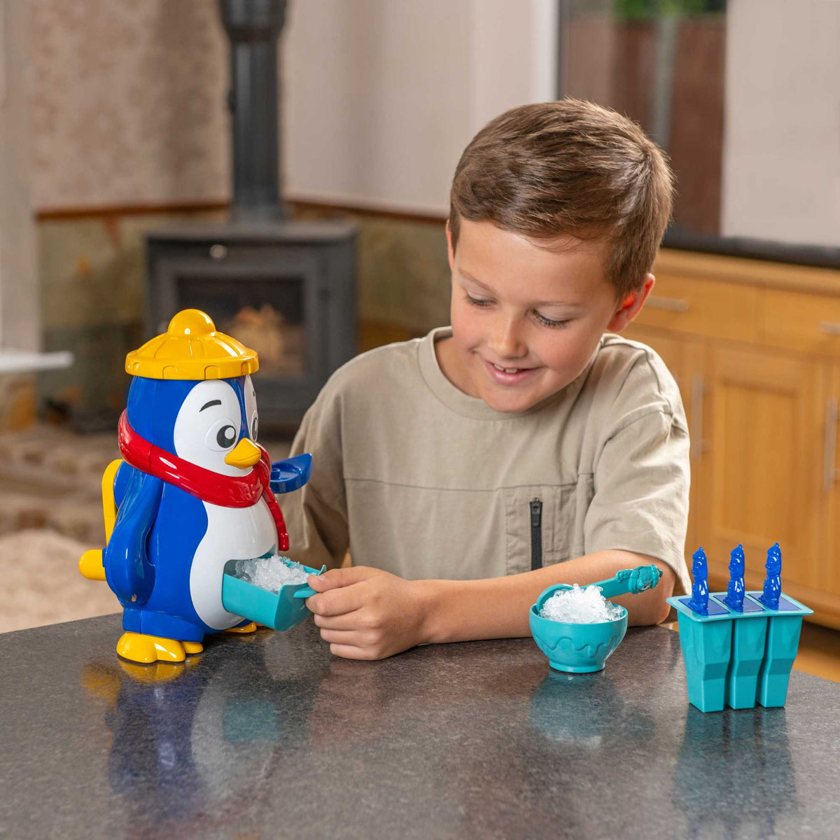 Polar Penguin Ice Maker Toy Set featuring a penguin-shaped ice crusher, ice lolly moulds, ice cube tray, and a bottle for syrups. Perfect for kids, this fun and educational set allows them to create delicious frozen treats, promoting creativity and learning about the science of freezing. 