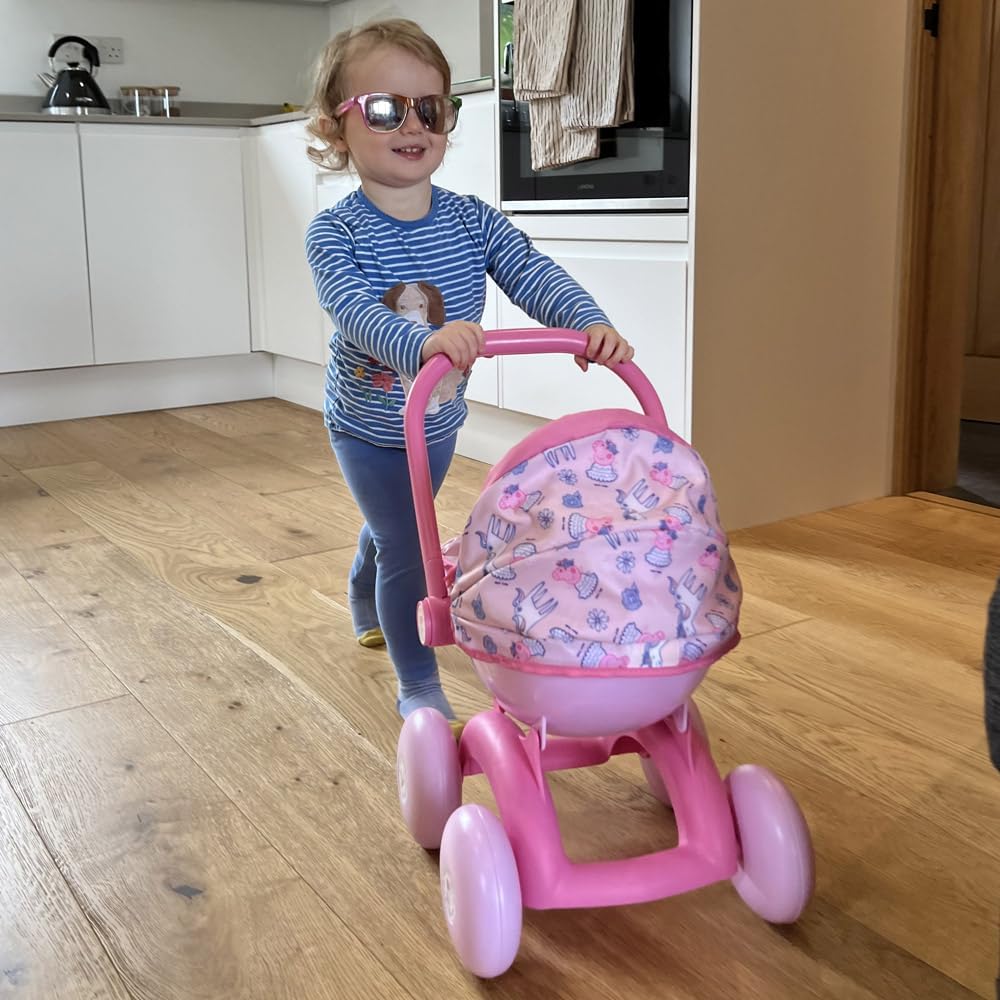 A child pushing the Peppa Pig 4-in-1 Pram with a doll inside, styled as a front-facing pushchair. The light pink body and Peppa Pig details enhance imaginative play.