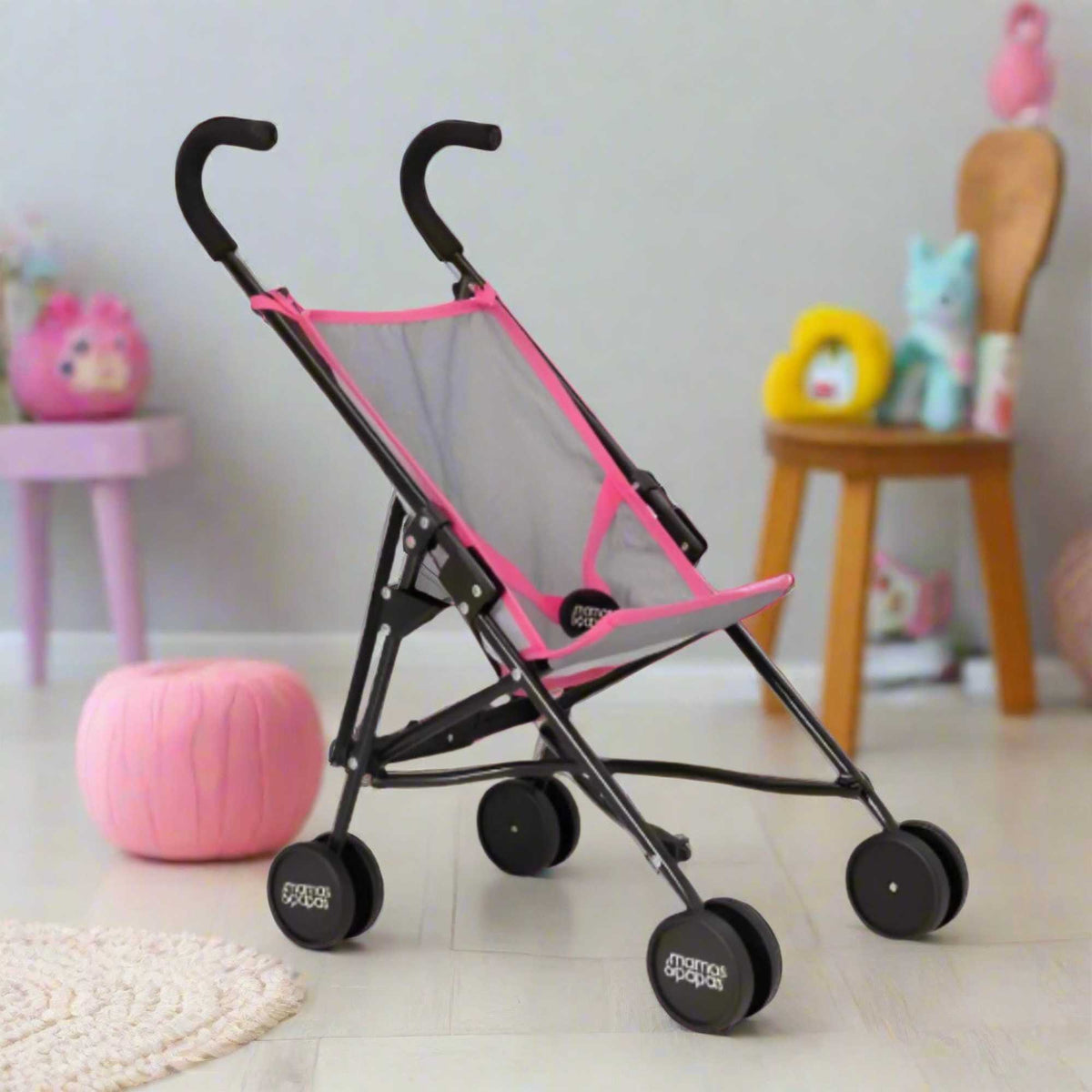 Mamas &amp; Papas Junior Doll Stroller in pink and grey, featuring a foldable and lightweight design for easy storage and portability, ideal for children&#39;s imaginative play with dolls.