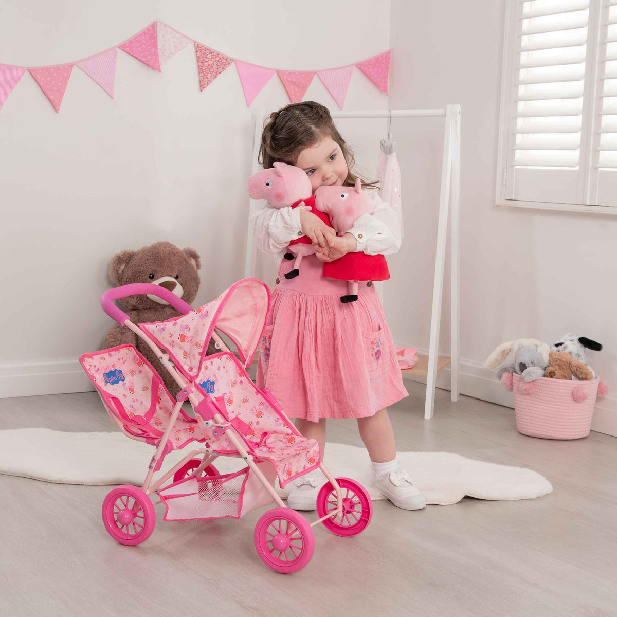 Peppa Pig Tandem Twin Doll Stroller: A pink double stroller with Peppa Pig graphics, designed for carrying two dolls side by side, ideal for toddlers and imaginative play.